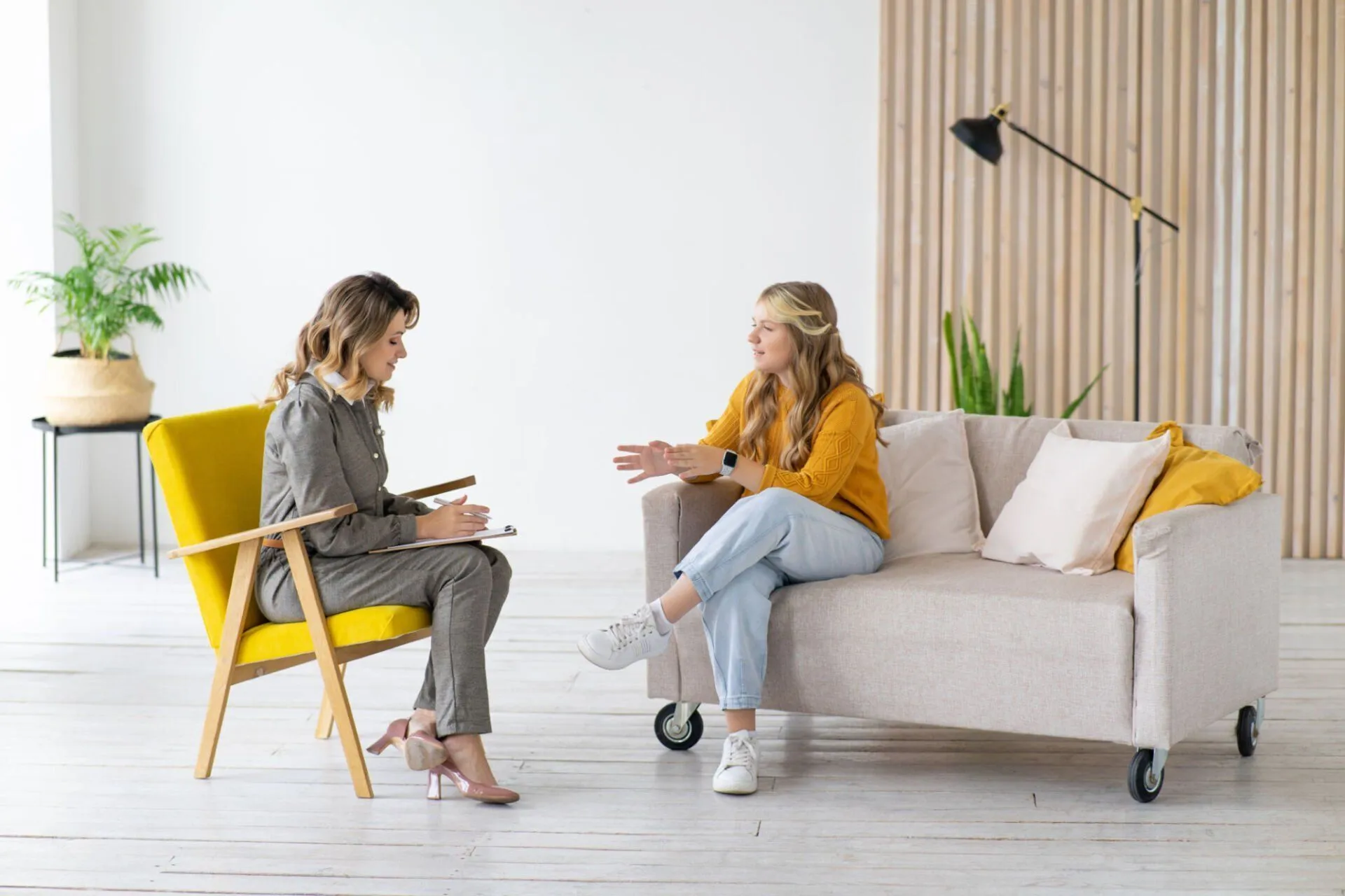 A therapist and a teenage client talking during a counseling session